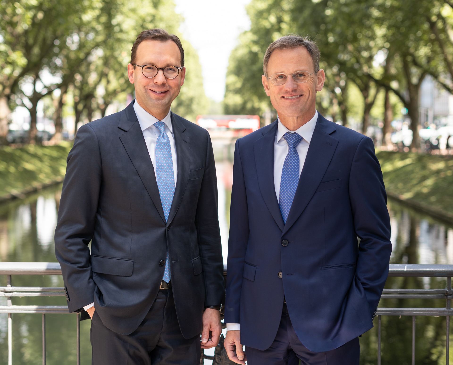 Notare Dr. Gerrit Wenz und Dr. Michael Schüller auf einer Brücke an der Königsallee in Düsseldorf